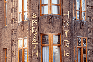 Voorgevel van Grand Hotel Amrâth Amsterdam met opvallende bakstenen architectuur en art deco letters.